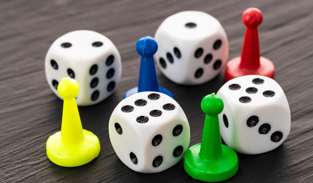 Bunte Spielfiguren und weiße Würfel auf einem Tisch beim Spielenachmittag in Ludwigsburg.