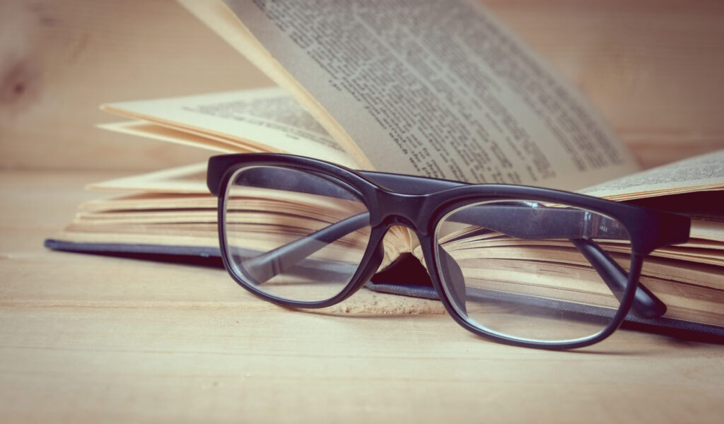 Old,Books,And,Glasses,On,A,Wooden,Table,With,Filter